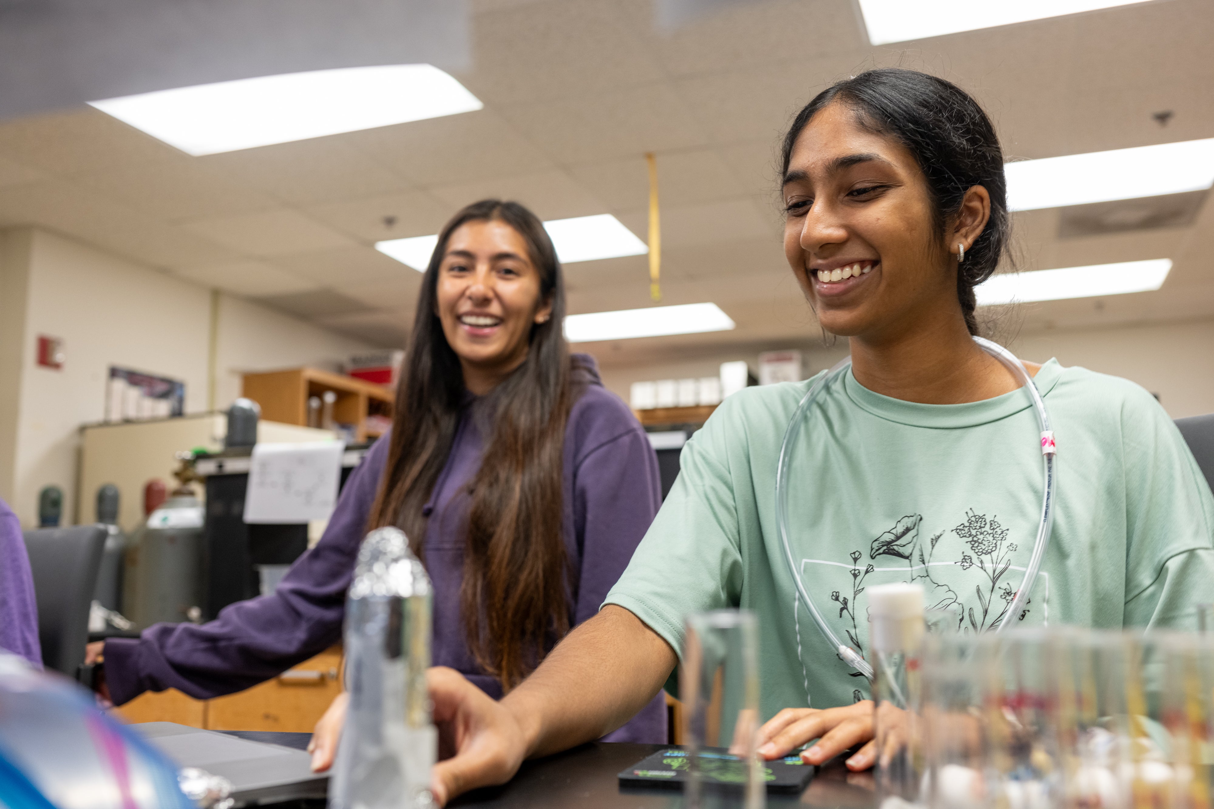 Two students in a lab, smiling.