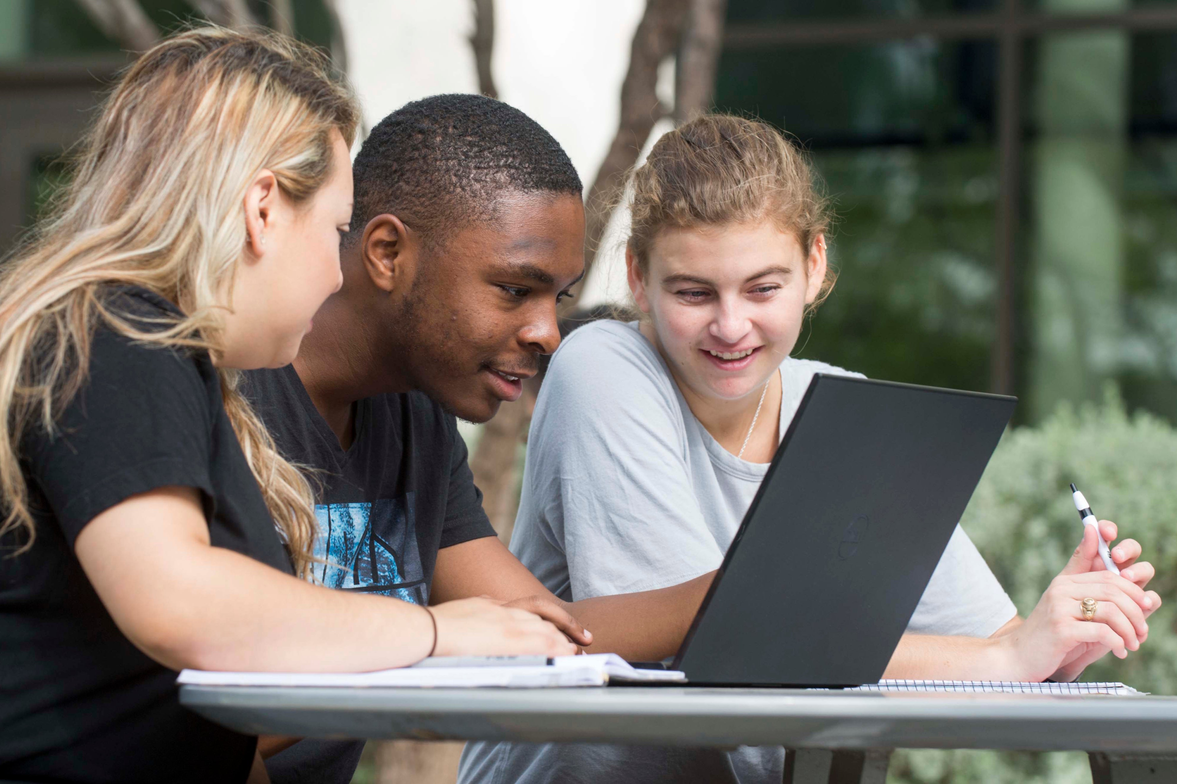 Three students looking at a computer screen.